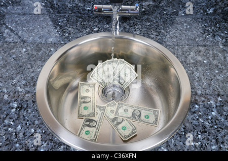 Waschbecken Sie mit US-Dollarnoten in Abfluss mit Wasser laufen, Konzept "Geld den Bach runter" Stockfoto