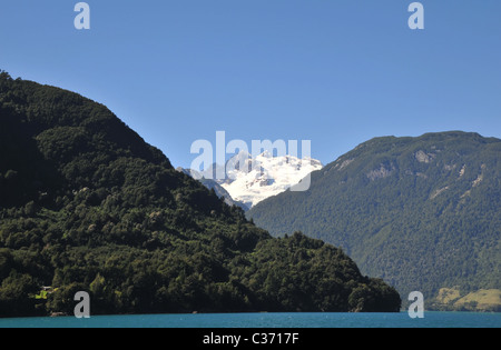 Blauer Himmel, weiße Gipfel Volcan Tronador über Anden Berghänge mit gemäßigten Regenwald, aus LakeTodos Los Santos, Chile Stockfoto