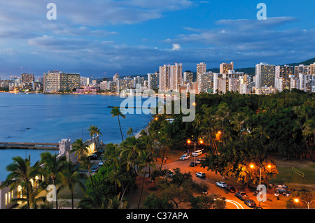 Einen hohen Winkel Dämmerung Blick auf Kapiolani Beach Park und der Hochhaus-Hotels entlang der Küste von Waikiki. Stockfoto