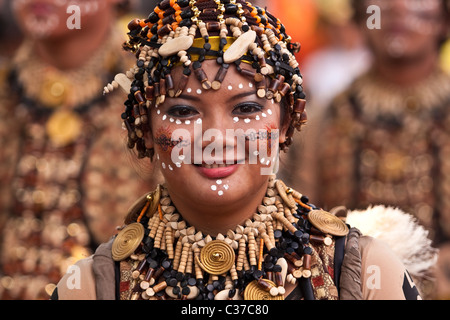 Eine Dame in einem braunen und schwarzen Perlen Kostüm mit den gleichen Perlen Kopfschmuck. Stockfoto