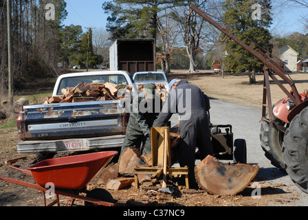 Männer, die Protokolle auf einem Holzspalter für Brennholz Spalten. Stockfoto