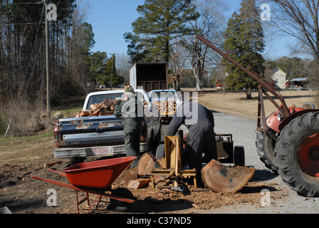Männer, die Protokolle auf einem Holzspalter für Brennholz Spalten. Stockfoto