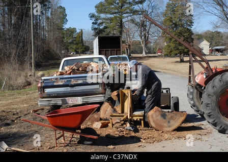 Männer, die Protokolle auf einem Holzspalter für Brennholz Spalten. Stockfoto