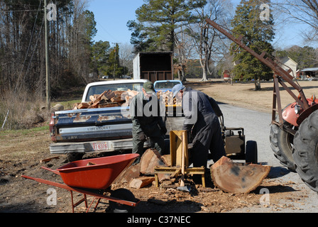 Männer, die Protokolle auf einem Holzspalter für Brennholz Spalten. Stockfoto