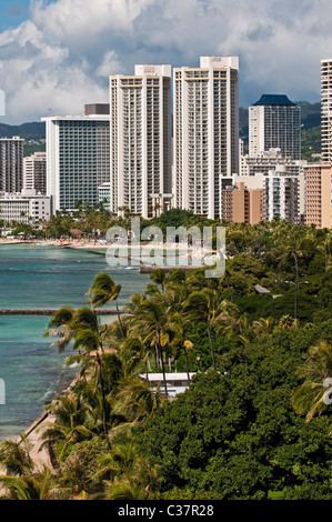 Eine erhöhte Ansicht über den Baumwipfeln des Kapiolani Beach Park gegenüber des Hotels und die Küste von Waikiki Beach. Stockfoto