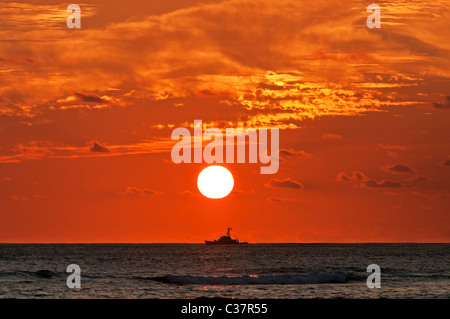 United States Coast Guard Cutter ist von der untergehenden Sonne, Silhouette, von Waikiki, Honolulu, Hawaii gesehen. Stockfoto