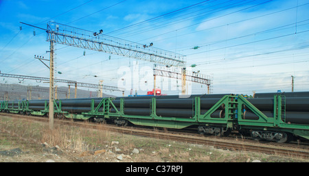 Eisenbahn-Plattformwagen mit Rohren am Bahnhof Stockfoto