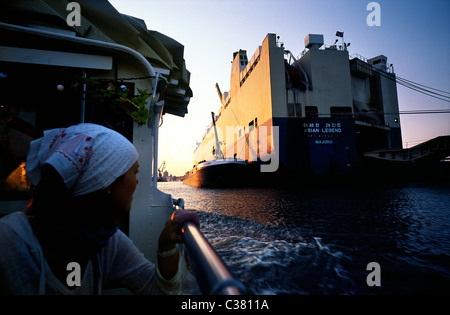 Party Boot MS Frau Hedi übergibt südkoreanischen GLOVIS Handelsschiff asiatischen Legende zum Sonnenuntergang im Hamburger Hafen besaß. Stockfoto