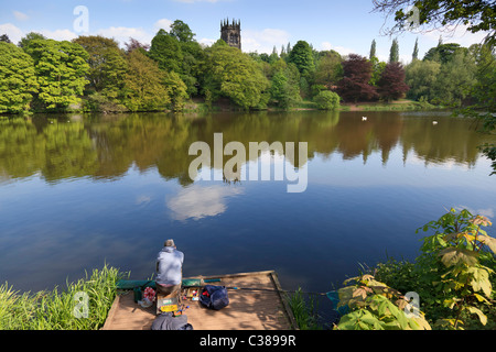 St. Marien Kirche über Lymm Damm mit ein einsamer Angler Angeln. Stockfoto