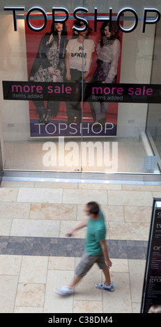 Eine Person geht vor ein Zweig der Topshop/Topman, Cambridge. Bestandteil der Gruppe "Arcadia" Stockfoto