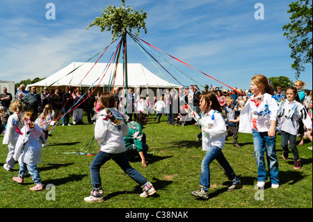 Dilwyn Dorf zeigen, Herefordshire, England. Mädchen Maibaum Tanz in England. Schulmädchen-Tanz um den Maibaum im Frühjahr fest. Stockfoto
