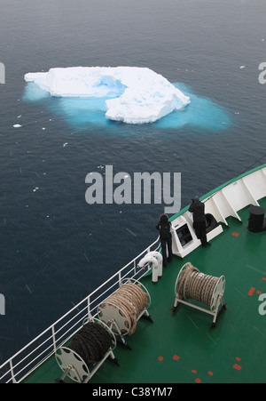 Zwei Passagiere auf polar Kreuzfahrtschiff Blick auf kleine Eiszeit Eisberg in [Lemaire-Kanal], [antarktischen Halbinsel] Stockfoto