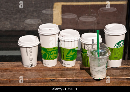 Fein säuberlich verworfen Kunststoff Kaffeetassen auf einer Bushaltestelle Bank, London, UK Stockfoto