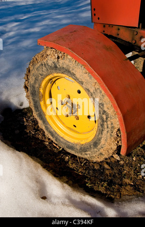 Fragment der alten gelben Traktor Rad mit Schlamm bedeckt. Stockfoto