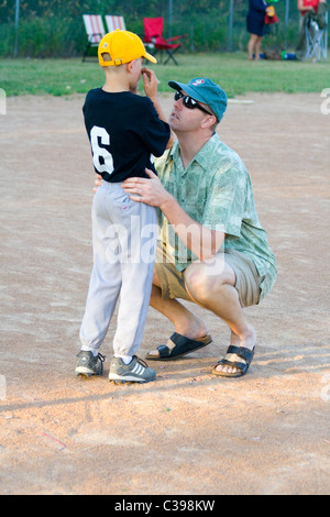 Verletzt der Jugend Baseball-Spieler von seinem Vater getröstet. St Paul Minnesota MN USA Stockfoto