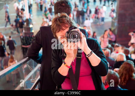 Ein begeisterter Fotograf in Times Square Manhattan bei Nacht Stockfoto