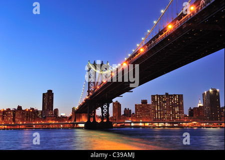 New York City Manhattan Bridge über den East River an der Dämmerung Licht mit Reflexionen und die Skyline der Innenstadt aus gesehen Stockfoto