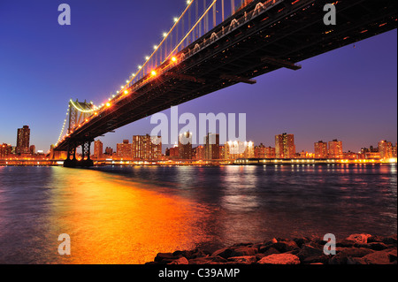New York City Manhattan Bridge über den East River an der Dämmerung Licht mit Reflexionen und die Skyline der Innenstadt aus gesehen Stockfoto