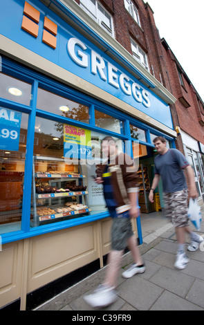 Zwei Kunden verlassen einen Zweig der Greggs der Bäcker. Stockfoto