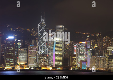 Beleuchtete Skyline von Hong Kong Island mit Reflexionen in der Nacht Stockfoto