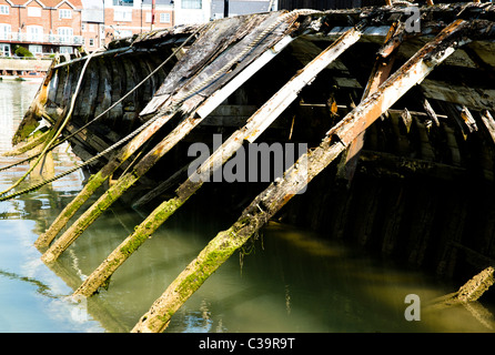 Eine Fäulnis Holzboot auf seiner Seite in den Fluss Arun in Littlehampton, Sussex Stockfoto