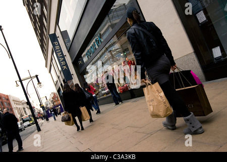 Ein Primark-Kunden nach einem Einkaufstag im Flagshipstore in der Londoner Oxford Straße hinunter Stockfoto