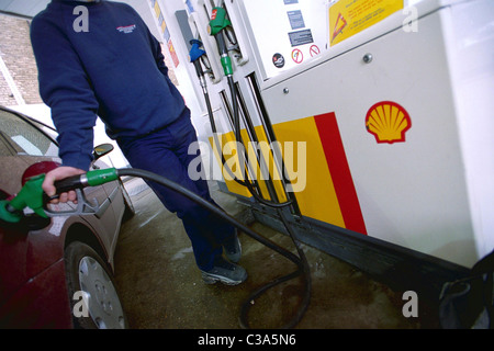 Ein Mann füllt sich sein Auto an einer Shell-Tankstelle Benzin Stockfoto