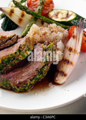 Lamm-Hinterteil mit einem Kräuter- und Senf Kruste Spargel Schalotten Zucchini und Tomaten Stockfoto