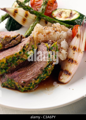 Lamm-Hinterteil mit einem Kräuter- und Senf Kruste Spargel Schalotten Zucchini und Tomaten Stockfoto