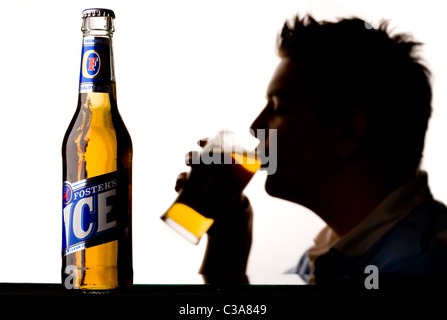 Ein Mann, einen Pint Fosters Eis Bier zu genießen. Stockfoto