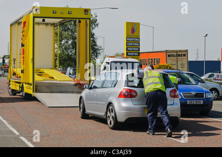 Silbernen Volkswagen Golf wird auf eine Erholung LKW geschoben. Stockfoto