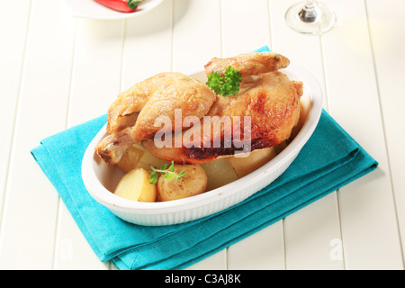 Brathähnchen und neuen Kartoffeln in eine Auflaufform geben Stockfoto