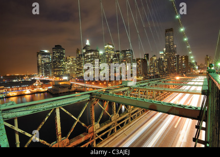 Blick auf Downtown Manhattan von der Brooklyn Bridge mit dem Verkehr von fliegen. Stockfoto