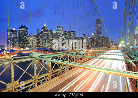 Blick auf Downtown Manhattan von der Brooklyn Bridge mit dem Verkehr von fliegen. Stockfoto