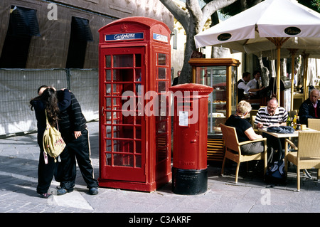 Junges Paar genießen einen privaten Moment neben dem britischen Kolonialzeit Telefonzelle und Säule-Box am Schlossplatz in Valletta. Stockfoto