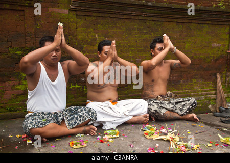 BALINESISCHE Familienmitglieder beten in PURA TIRTA EMPUL ein Hindu-Tempel Komplex und kalten Quellen - TAMPAKSIRING, BALI, Indonesien Stockfoto