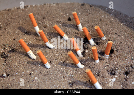 Zigarettenkippen im Sand gerodet Stockfoto