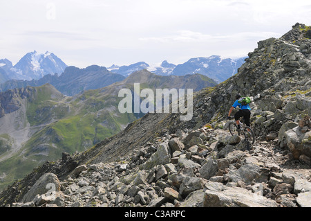 Ein Mountainbiker reitet auf einem felsigen Pfad hoch in den Bergen oberhalb der Skiort Courchevel in Frankreich. Stockfoto