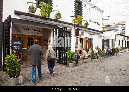 Zwei Personen betreten des Ubiquitous Chip Restaurants: Ashton Lane, West End, Glasgow. Menschen sitzen an Tischen im Außenbereich der Bar Stockfoto