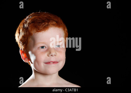 Porträt eines sieben Jahre alten Jungen mit roten Haaren und blauen Augen. Stockfoto