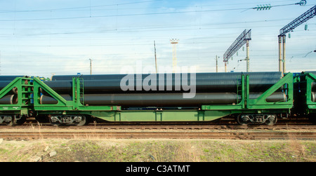 Eisenbahn-Plattformwagen mit Rohren am Bahnhof Stockfoto