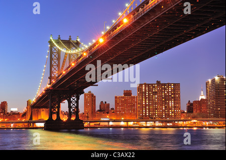 New York City Manhattan Bridge über den East River an der Dämmerung Licht mit Reflexionen und die Skyline der Innenstadt aus gesehen Stockfoto