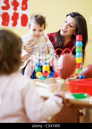 weiblichen Kleinkind und 2-3 Jahre Mädchen spielen mit Maracas im Kindergarten. Vertikale Form Stockfoto