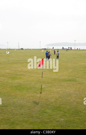 Menschen spielen Pitch und Putt auf dem Mackerston Putting Green in der Küstenstadt Largs, North Ayrshire, Schottland, Großbritannien Stockfoto