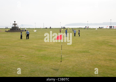 Menschen spielen Pitch und Putt auf dem Mackerston Putting Green in der Küstenstadt Largs, North Ayrshire, Schottland, Großbritannien Stockfoto