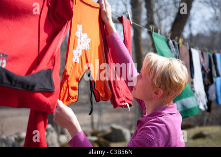 Nahaufnahme von Frau nasse Wäsche auf der Wäscheleine aufhängen Stockfoto