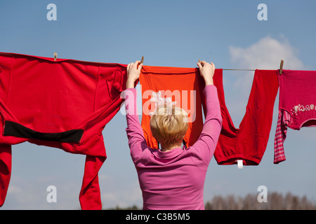 Nahaufnahme von Frau nasse Wäsche auf der Wäscheleine aufhängen Stockfoto
