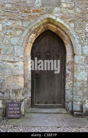 Seitentür und Schild an alle Heiligen Kirche Thwing East Yorkshire Stockfoto