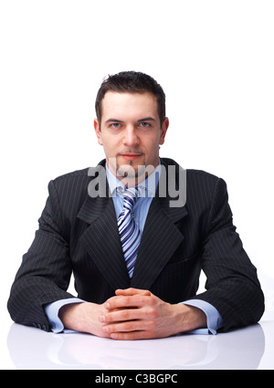 Porträt eines zuversichtlich Geschäftsmann sitzt mit seinen Händen gefaltet auf weißem Hintergrund Stockfoto