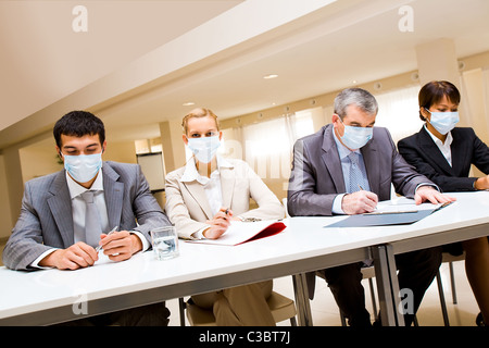 Porträt der Gruppe von Geschäftspartnern in Schutzmasken während der Arbeit Stockfoto